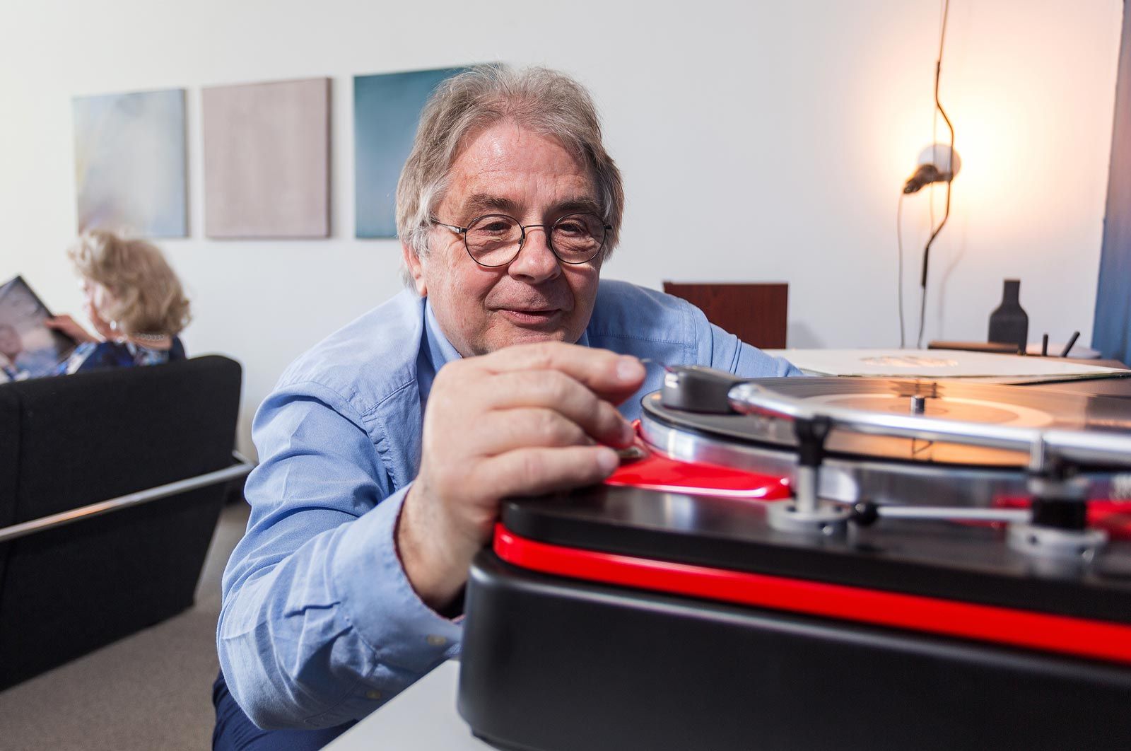 man playing record album on turntable