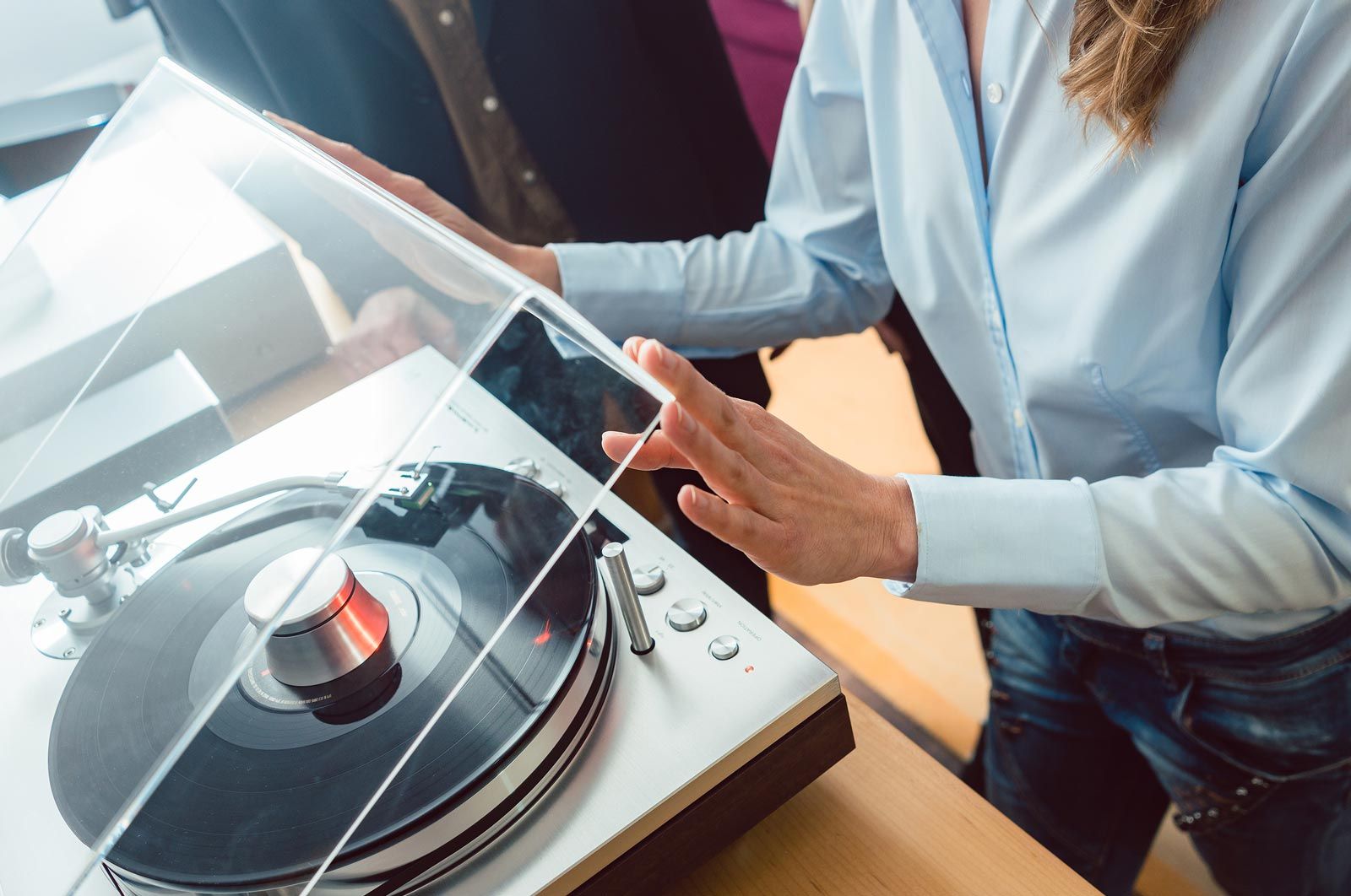 woman playing record album on turntable